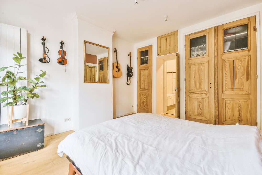 chambre naturelle avec portes en bois et linge de lit blanc