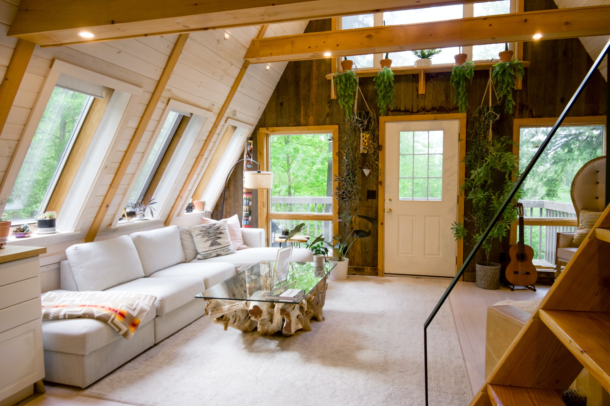 Salon tout en bois avec plantes et meubles blancs