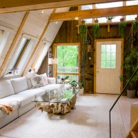 Salon tout en bois avec plantes et meubles blancs