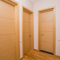 Couloir intérieur avec plusieurs portes en bois clair