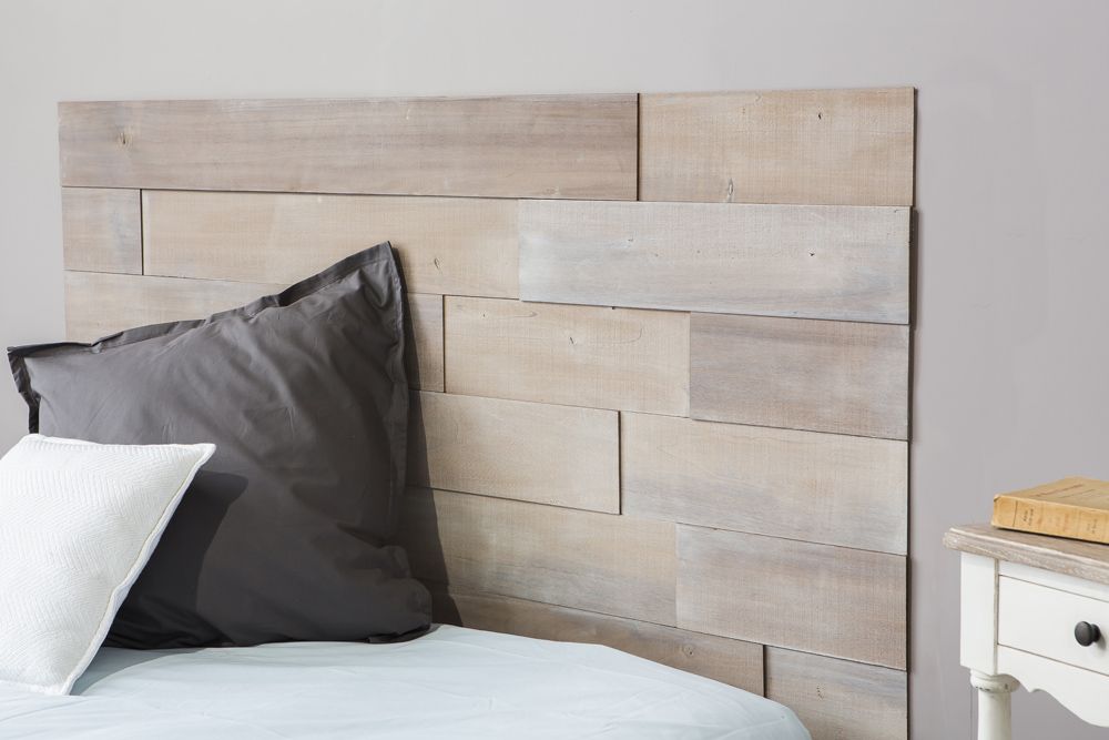 tête de lit en bois sur un mur gris